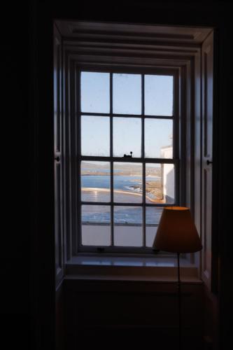 a window in a room with a view of an airport at Principal Keeper's Cottage at Sumburgh Lighthouse, Shetland Islands in Sumburgh