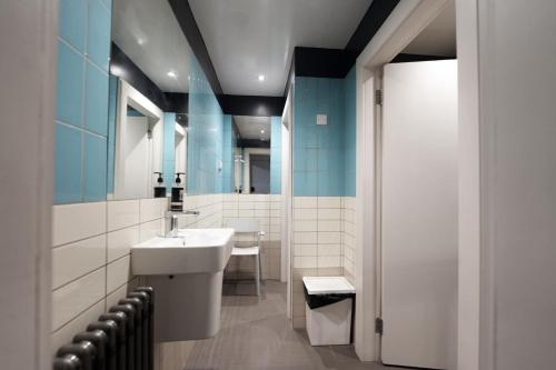 a bathroom with a sink and a mirror at Revolver Edinburgh in Edinburgh