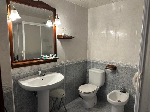 a bathroom with a sink and a toilet and a mirror at Can Genis Turismo Rural in Peralada