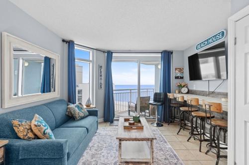 a living room with a blue couch and a table at Oceanside Escape Condo w/ Ocean Views + Pools in Myrtle Beach