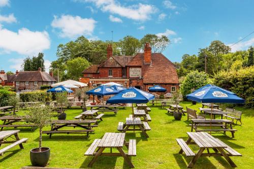 a group of picnic tables with umbrellas in front of a building at Flower Pot Hotel in Henley on Thames