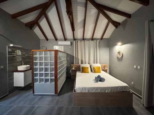 a bedroom with a large bed and a bathroom at Bungalow Racoon Le Gosier in Le Gosier