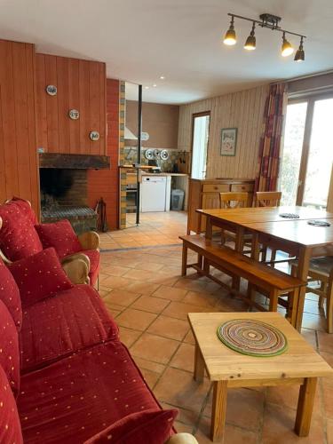 ein Wohnzimmer mit Sofas und einem Tisch sowie eine Küche in der Unterkunft Chalet L'Eider in Bolquere