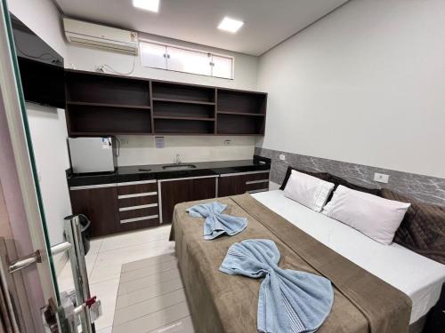 a bedroom with a bed with towels on it at Suítes Vivence Hotel in Goianésia