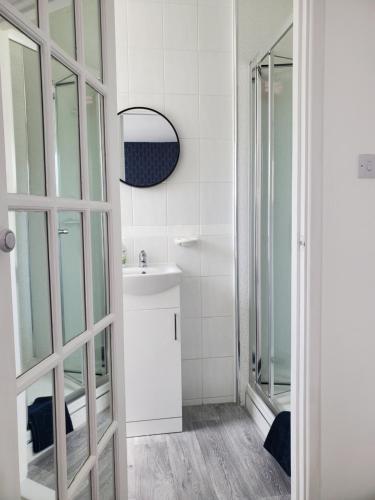 a bathroom with a sink and a mirror at Beachside 1 in Saint Helier Jersey