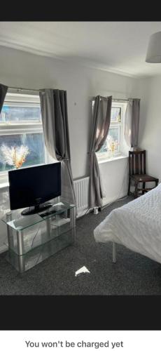 a bedroom with a bed and a tv on a glass table at Conner house in Middlesbrough