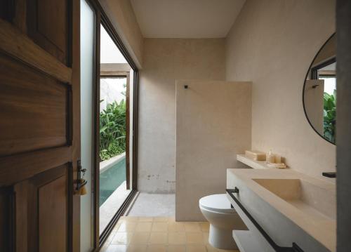 a bathroom with a toilet and a sink and a mirror at Luxury Suite by La Casa Verde in Campeche