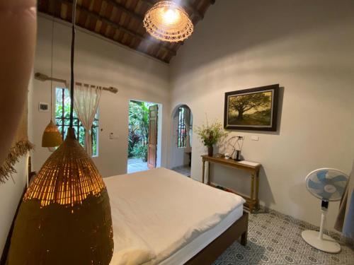 a bedroom with a bed with a chandelier at Nhà Lúa Homestay in Ninh Binh