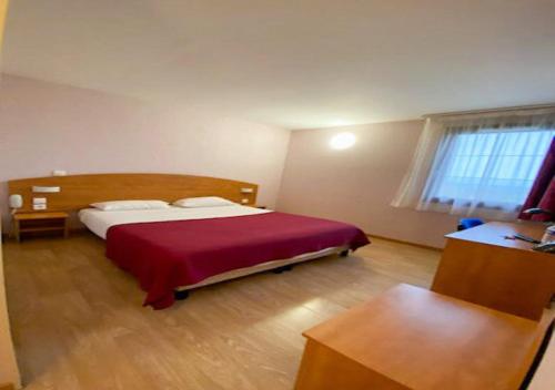 a bedroom with a bed with a red blanket at Contact Hôtel - Prim Witry - Reims Nord in Reims