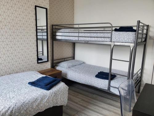 a room with two bunk beds and a mirror at Beachside 1 in Saint Helier Jersey