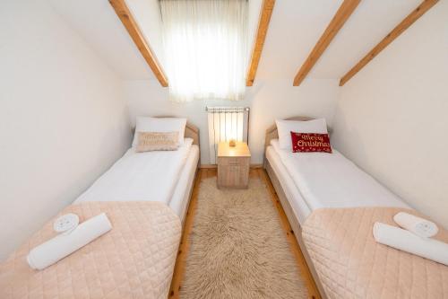 two beds in a small room with a window at Our House Apartments in Kolašin