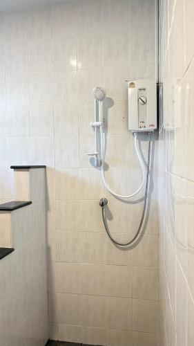 a shower in a bathroom with a hair dryer on the wall at Kamala Garden Bungalows in Kamala Beach
