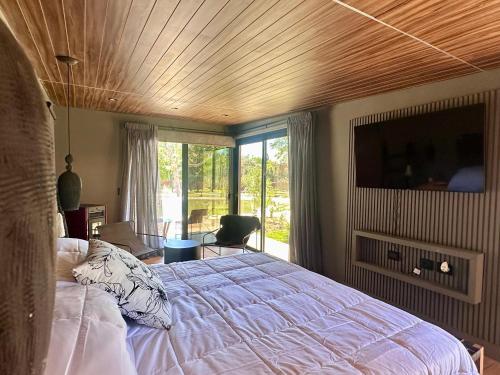 a bedroom with a bed with a wooden ceiling at LÜN Lodges in Chacras de Coria
