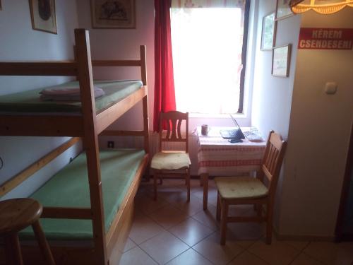 Zimmer mit Etagenbetten, einem Schreibtisch und einem Fenster in der Unterkunft Rita Vendégszobák in Sopron