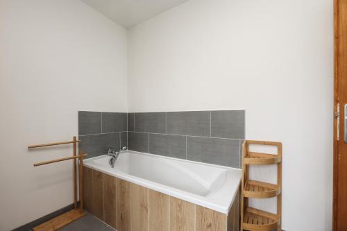 a white bath tub in a bathroom with a ladder at Gîte À la Bonne Compagnie in Preures