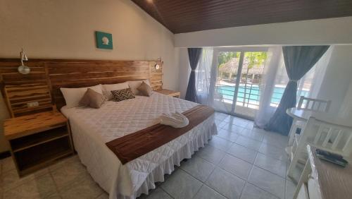 a bedroom with a bed and a large window at Hotel MarBrissa in Puerto Barrios