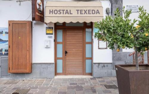 a building with a wooden door and a sign on it at TeXeda Room Suites in Tejeda