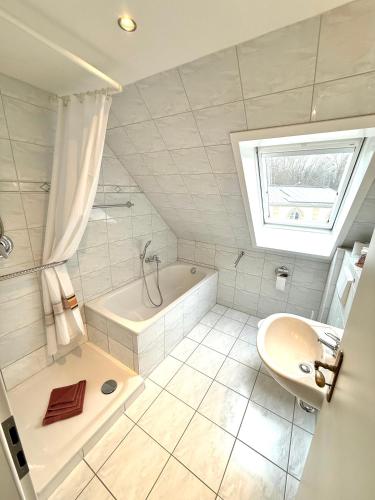a white bathroom with a tub and a sink at Schlösschen am Rhinufer in Alt Ruppin