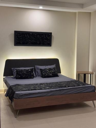 a bed with two pillows on it in a room at The Cubee Nest- Luxury 1BHK in Central Bahria Enclave in Islamabad