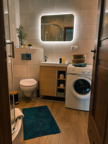 a bathroom with a toilet and a washing machine at Fotuso House in Majdany Wielkie