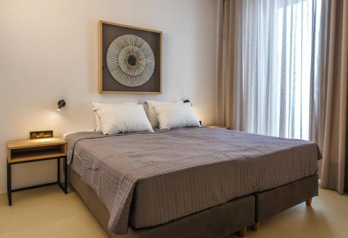 sypialnia z dużym łóżkiem i oknem w obiekcie Skylines Estate Paros w mieście Paros