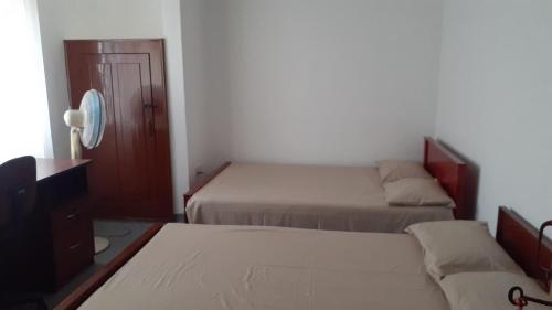 a bedroom with two beds and a tv and a mirror at Thoughtfully Updated 1960s Jaffna House in Jaffna