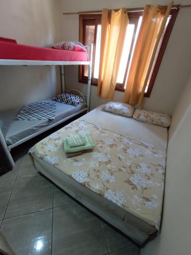 a bedroom with two bunk beds and a window at Pousada Nilda in Pântano Grande