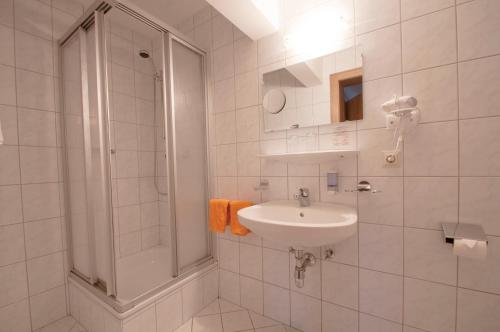 a white bathroom with a sink and a shower at Hotel Alpenfriede in Jerzens