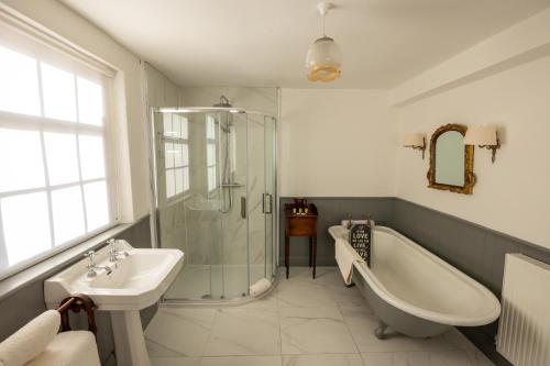 a bathroom with a shower and a tub and a sink at Noan Country House B&B in Cashel