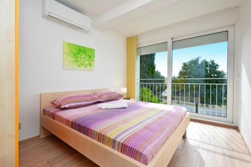 a bedroom with a bed and a large window at Apartment Tina Split in Split