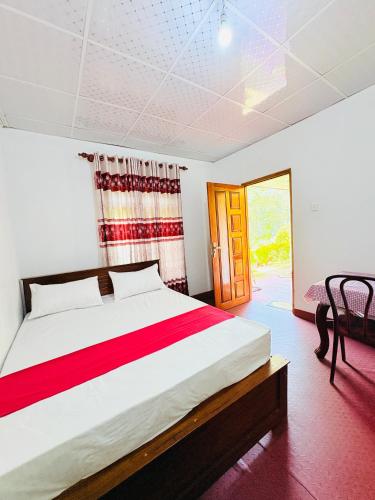 a bedroom with a large bed and a table at GREENISH INN (ROOMS) in Nanu Oya