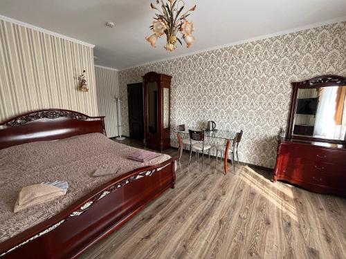 a bedroom with a bed and a table and a chandelier at Готель Козацький in Zvenyhorodka