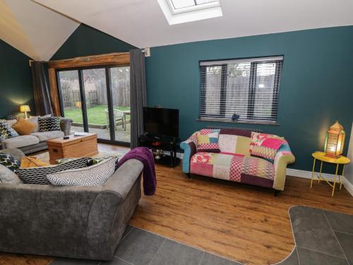 a living room with a couch and a table at Otter's Rest in Droitwich