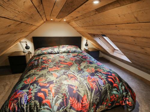 a bedroom with a large bed in a attic at The Barn on The Lagoon in Droitwich