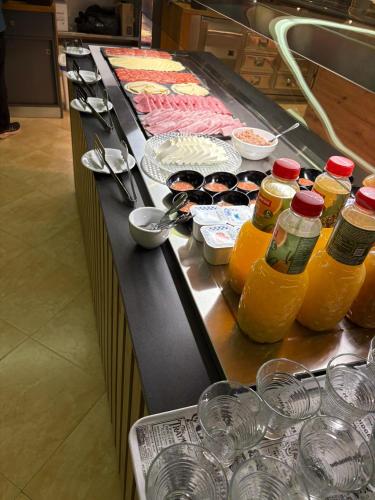 a buffet line with bottles and glasses of orange juice at Hotel Teruel in Vinarós