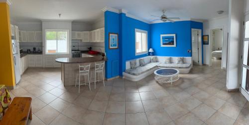 a large kitchen with blue walls and a bar at Precioso Dpto a 20m de la playa Con Aire Acondicionado en Ambos Dormitorios Club Casablanca in Same