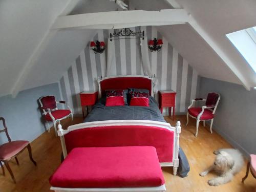 a bedroom with a bed with red pillows and a dog at suite nature huelgoat in Bannalec