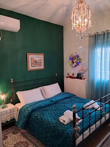a bedroom with a bed with a green wall at Villa Excelsior in Korinthos