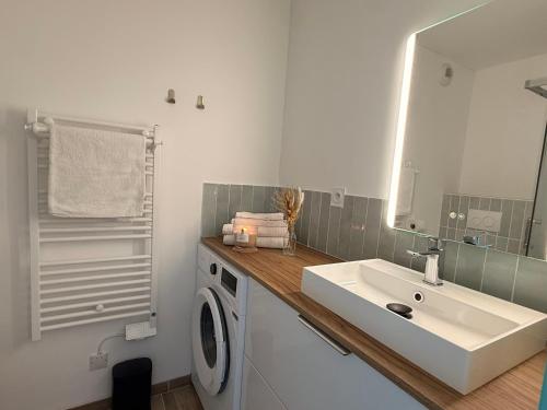 a bathroom with a sink and a washing machine at Le Petit Bleu Studio - Boulouris in Saint-Raphaël