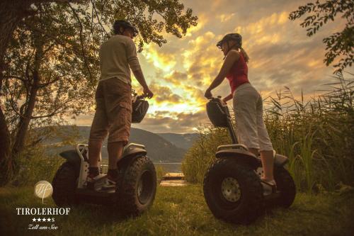 a man and a woman riding on quad bikes in the grass at Superior Hotel Tirolerhof - Zell am See in Zell am See
