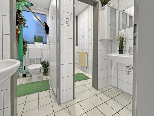 a bathroom with two sinks and a toilet at AlbRooms Nürtingen Monteur & Business Privatzimmer in Nürtingen