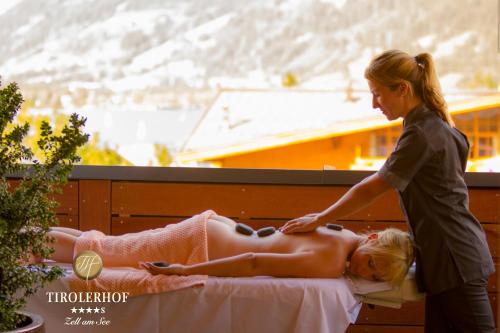 a woman is giving a woman a massage at Superior Hotel Tirolerhof - Zell am See in Zell am See