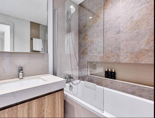 a bathroom with a sink and a glass shower at Private Room in Premium Burj Vista Downtown Apartment with Burj Khalifa View in Dubai