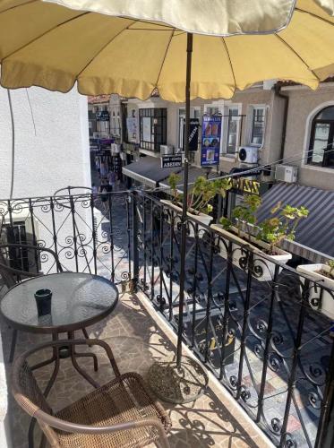 a table and chairs with an umbrella on a balcony at Galeb Apartment Ohrid in Ohrid