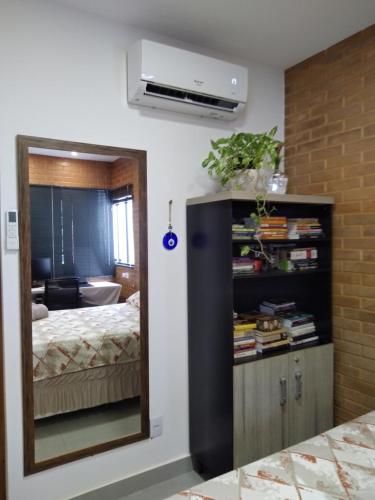 a room with a bedroom with a bed and a mirror at Casa em local tranquilo - Bairro Recanto dos Pássaros in Cuiabá