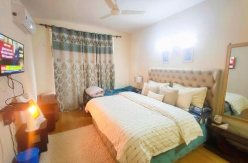 a bedroom with a bed and a tv in it at Budget Condo Family Stay 2 BHK in Mohali