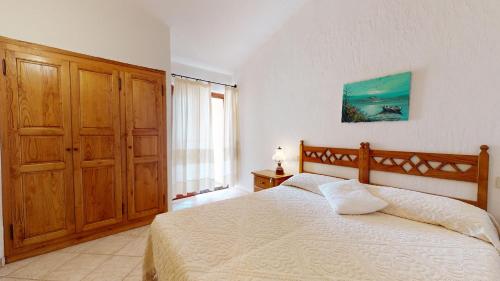 a bedroom with a bed and a large window at Villetta Ginepri in Cannigione