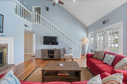 a living room with a red couch and a tv at Sunset Daze by Youngs Suncoast in Gulf Shores