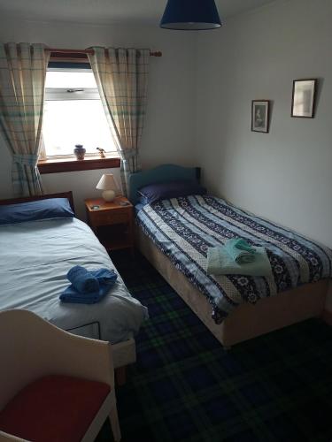 a bedroom with two beds and a window at Rosemarie's B&B in Lochcarron