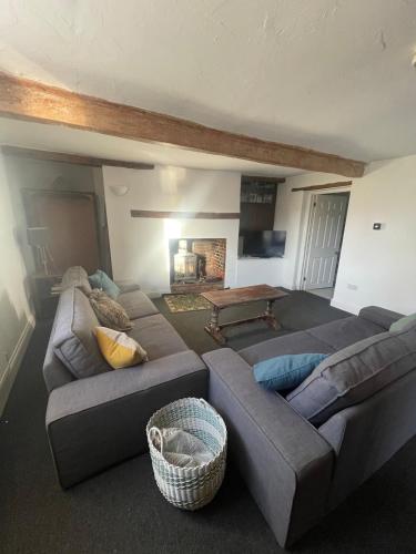 a living room with two couches and a table at Old Swan Cottage in Great Massingham